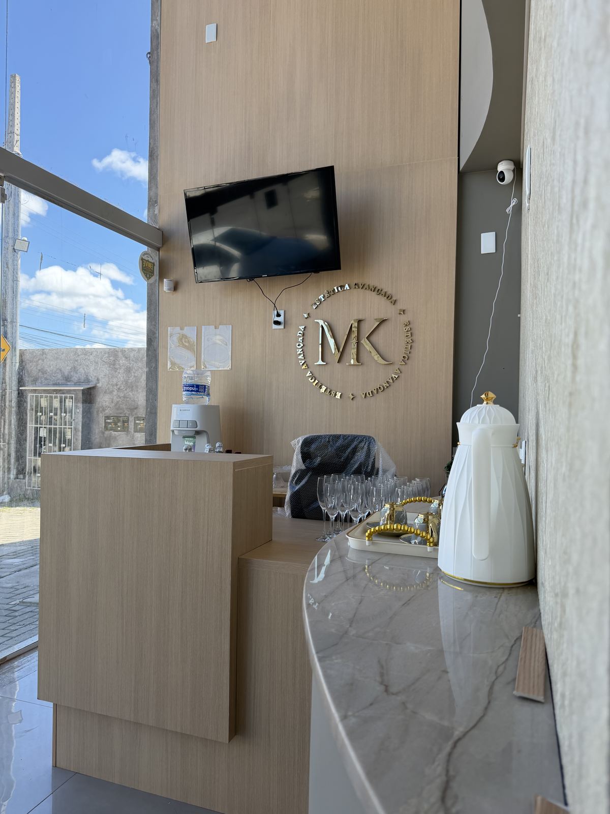 Recepção da MK Estética Avançada, com selo dourado MK na parede